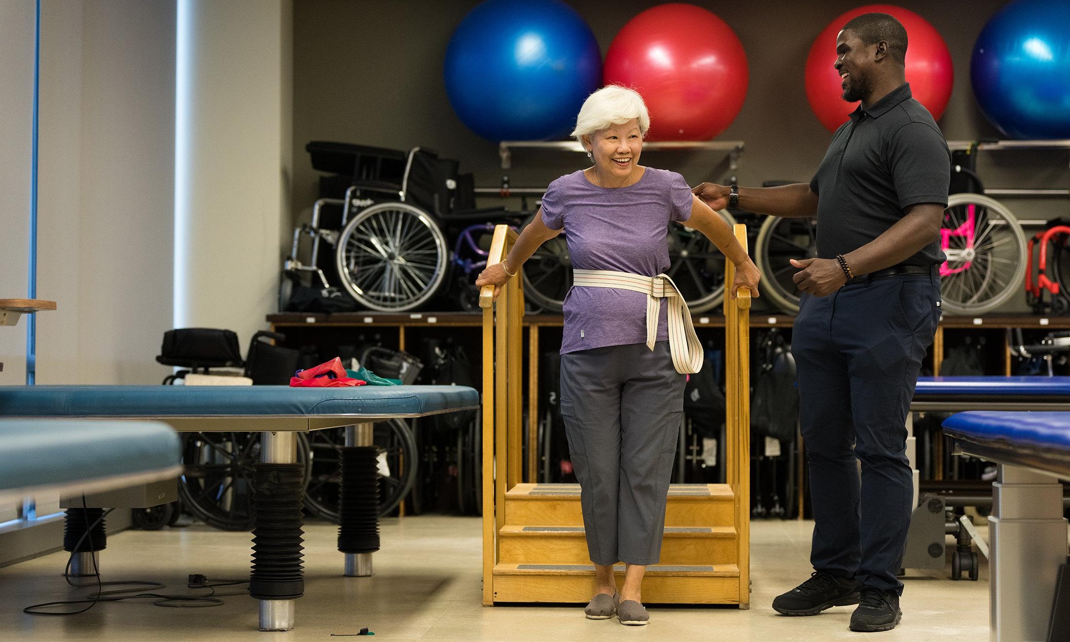 One person helping another person up stairs in a gym